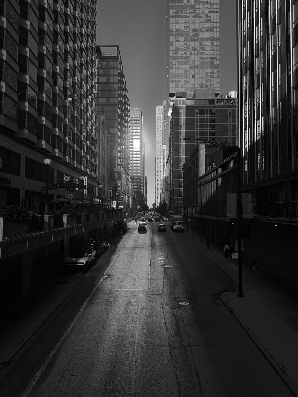 Sun down the length of a street between skyscrapers
